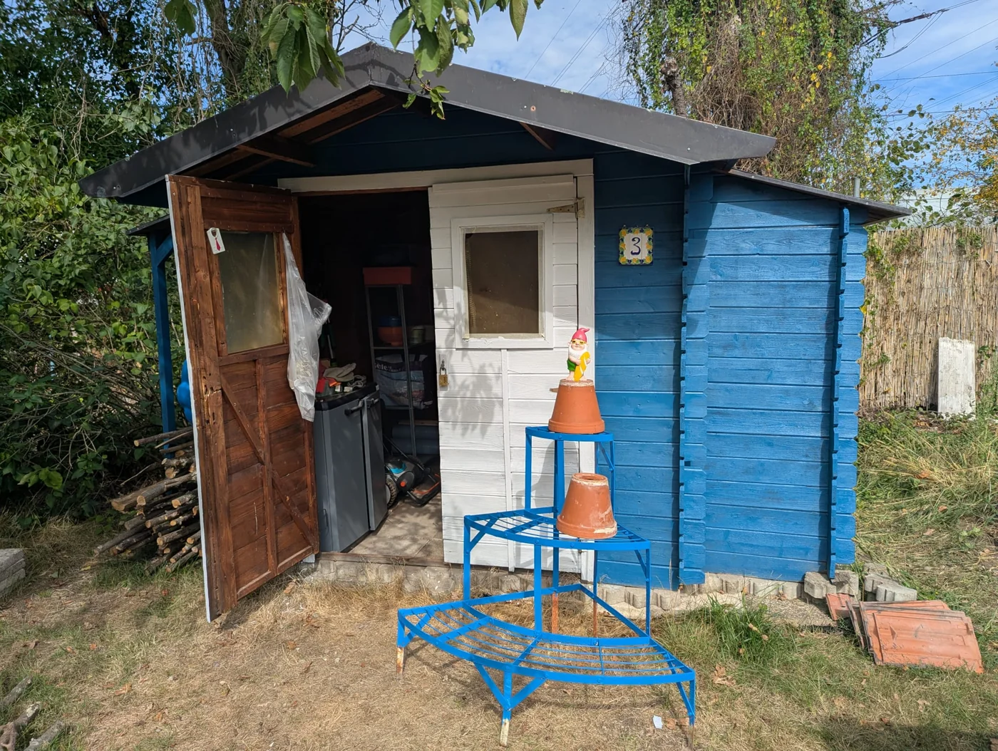 Original photo: a blue garden shed with a white door and garden gnome